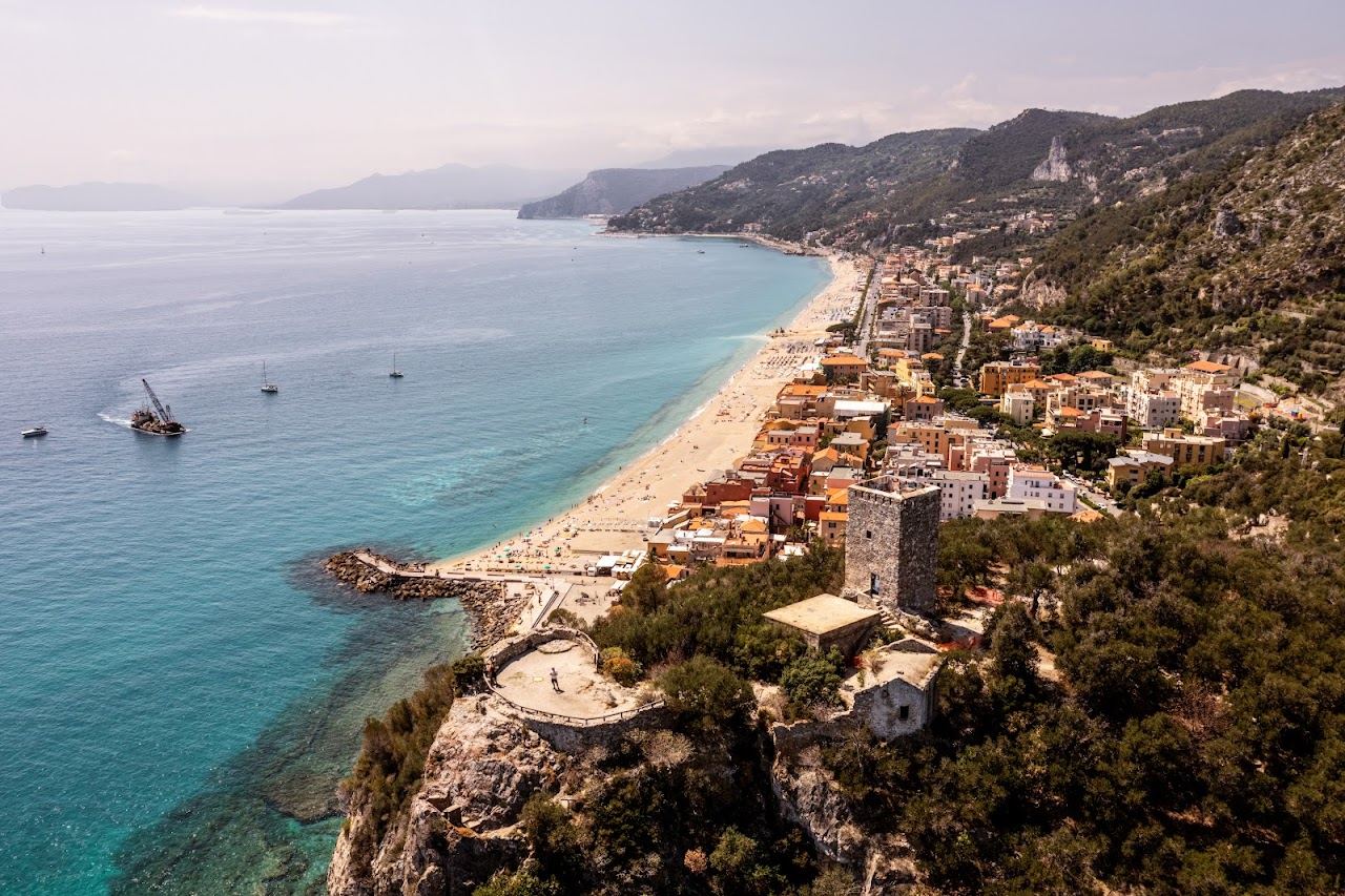 The sand of Varigotti with pastel village houses along the shore on the Riviera di Ponente in Liguria