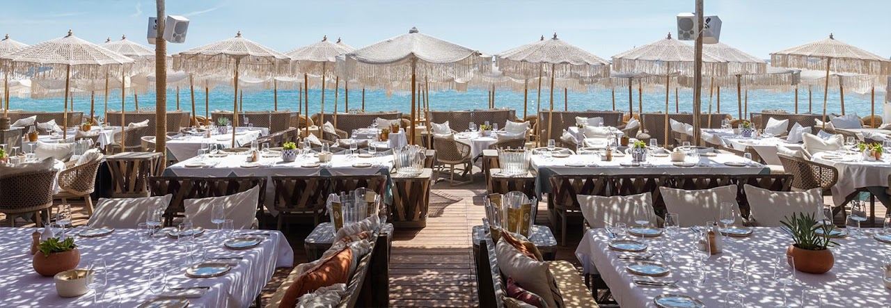 Sunbeds and parasols on the sand at Verde Beach on Pampelonne, Ramatuelle, with the restaurant terrace behind