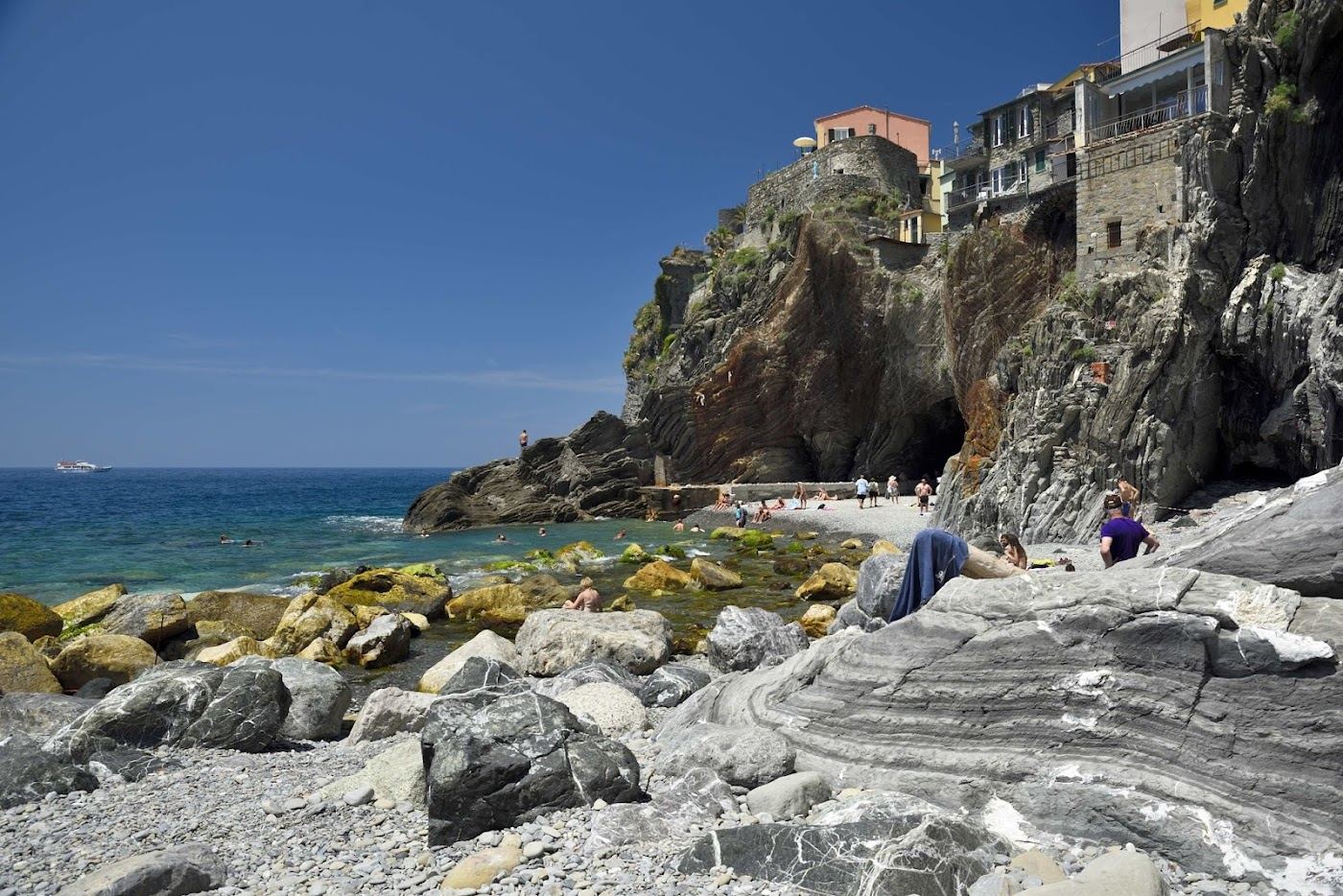 The pastel harbour of Vernazza with its small beach tucked beside the piazza in the Cinque Terre