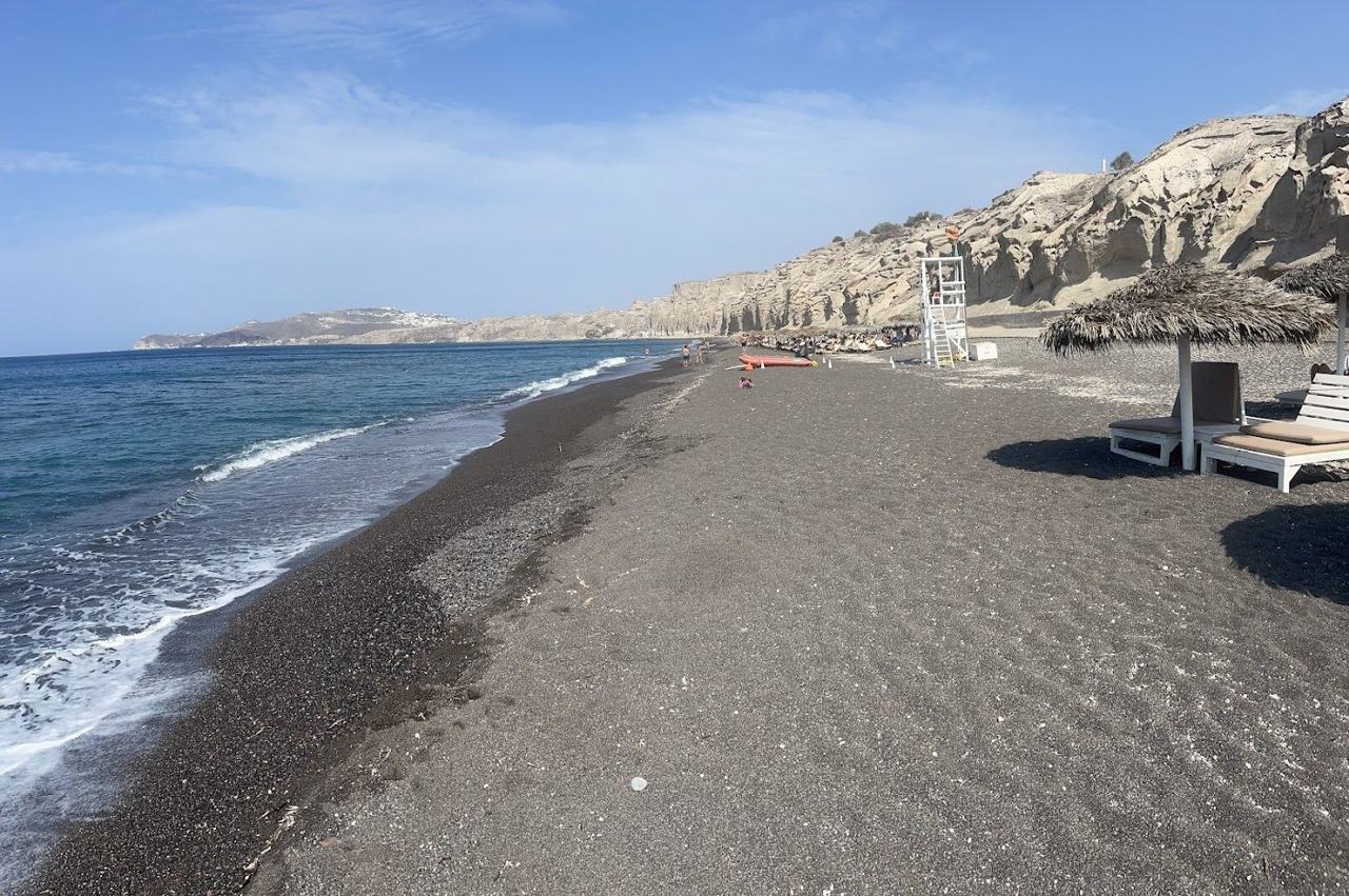 Wind carved white pumice cliffs above the dark sand of Vlychada Beach on the south coast of Santorini