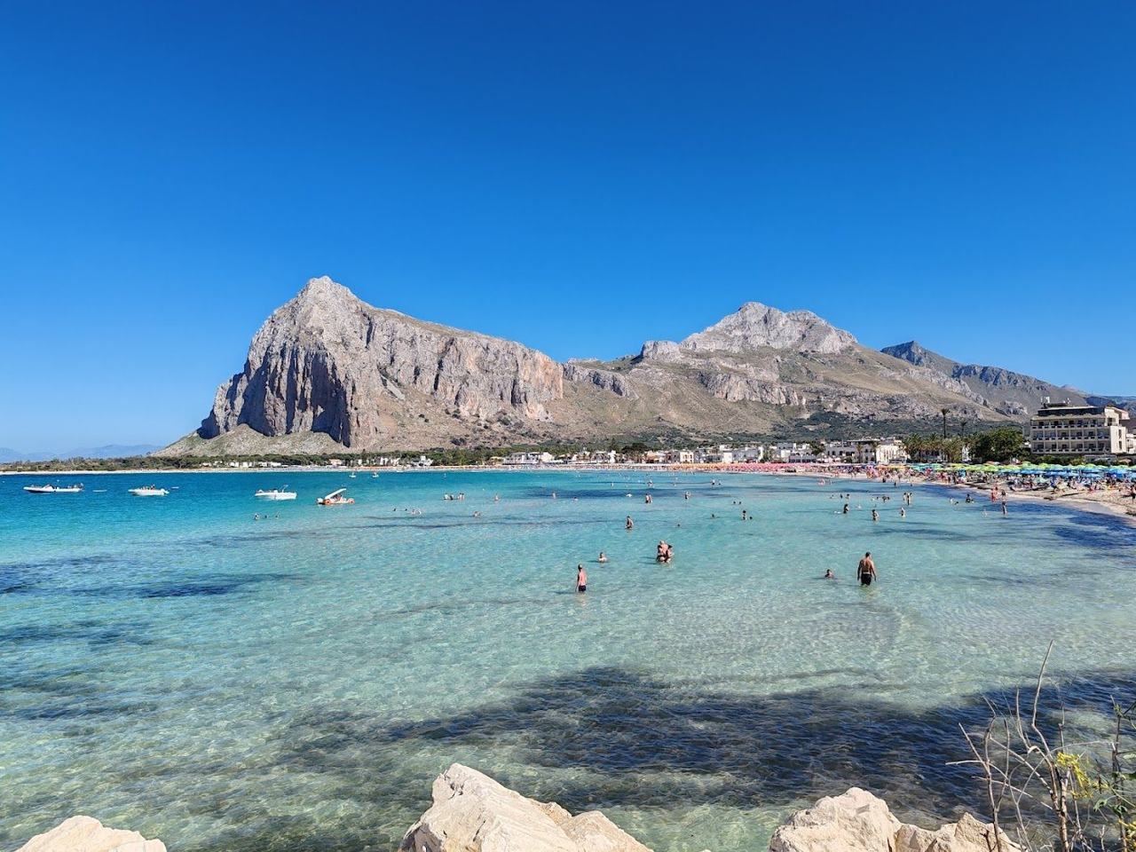The crescent of pale sand and clear shallow sea at San Vito Lo Capo in Sicily