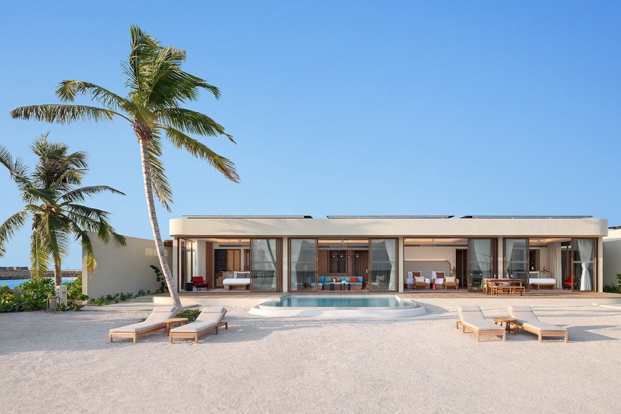 A warm tropical beach with white sand and calm turquoise lagoon under clear winter sun