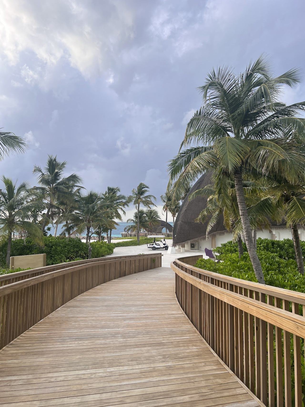 A private white sand beach and calm turquoise lagoon by overwater villas in the Maldives
